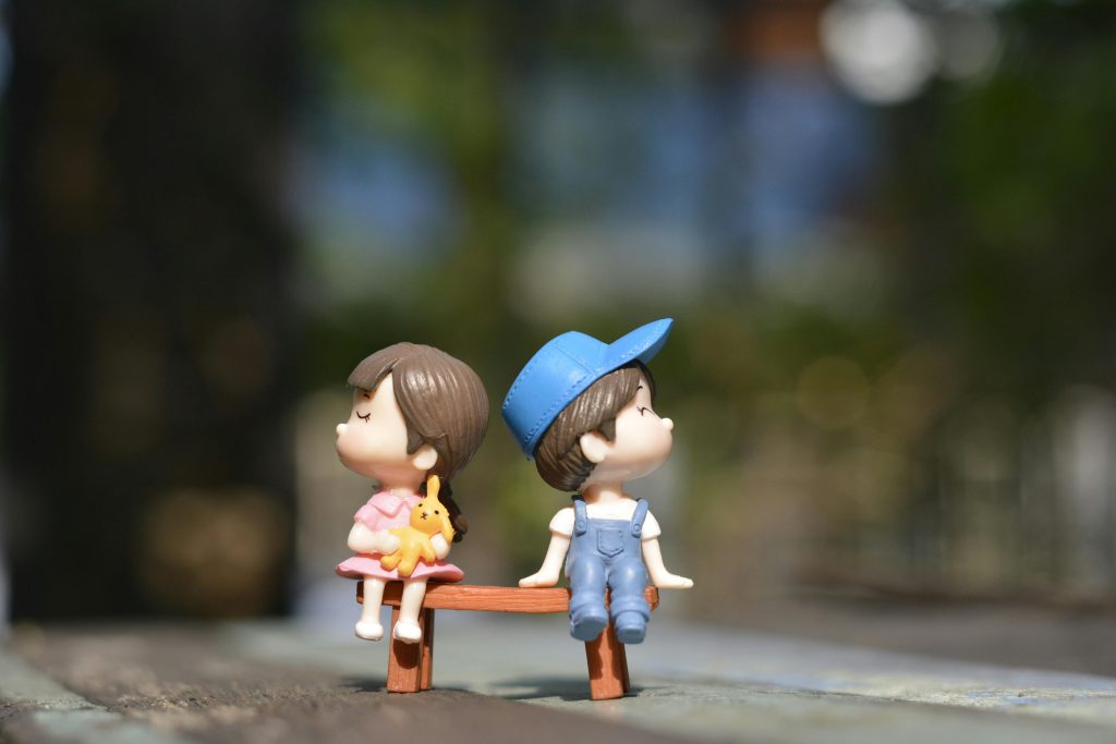 An image to two figurines (male and female) faced different direction while sitting on a bench. This image is included in a blog post on how to deal with intimacy if you hate physical touch.